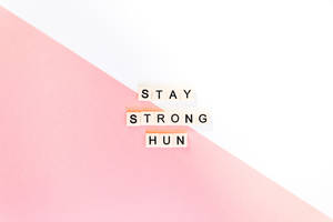 粉紅與白色背景上寫有「STAY STRONG HUN」的勵志文字方塊。