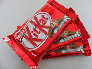 三塊紅色包裝的KitKat朱古力棒堆疊在白色背景上。 — 糖果 GIF 壁紙