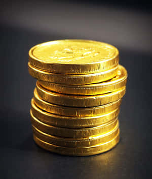 深色表面上的一堆金色包裝朱古力金幣 — 錢 壁紙