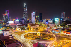 夜晚的城市，明亮的燈光和圍繞中央迴旋處移動的汽車軌跡。