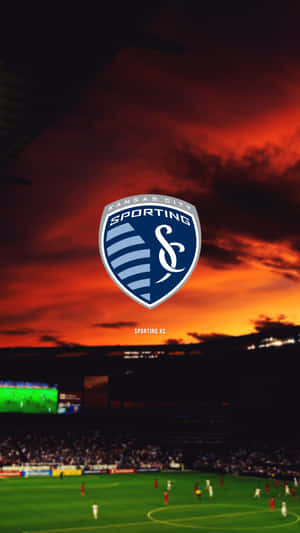 日落時分足球場上空的 Sporting KC 標誌，場上有球員。 — 足球 壁紙