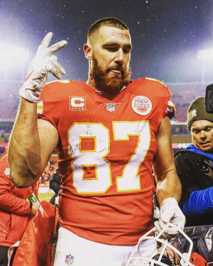 NFL球員87號穿紅色球衣在夜間球場上做手勢