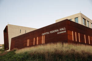 Capitol Federal Hall商業建築，帶有鏽色金屬面板和黃昏時發光的燈光。