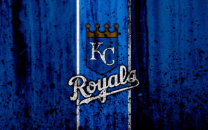 KC Royals 棒球隊標誌在破舊的藍色牆壁上，帶有白色條紋和黑色濺點。