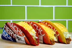 三個Doritos Locos Tacos配芝士和生菜放在木質表面上。