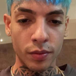 藍髮頸部有紋身的年輕男子，戴著金鏈