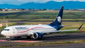 Aeromexico 飛機在跑道滑行，靠近山脈和城鎮。