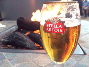 冰凍的 Stella Artois 啤酒旁邊是石頭露台上發光的戶外火坑。