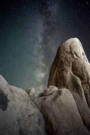 岩石框住星空夜空下充滿活力的銀河系。
