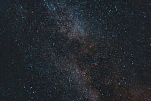黑暗夜空中的銀河系，帶有藍色和橙色的星星。