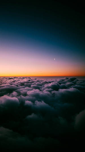 寧靜的黃昏天空，新月高懸於雲海之上。