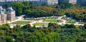 一個巴黎花園的鳥瞰圖，擁有噴泉和古典建築，周圍環繞著樹木。