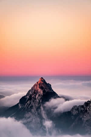 日出時分，山峰聳立於雲海之上，天空呈現粉紅色和橙色。