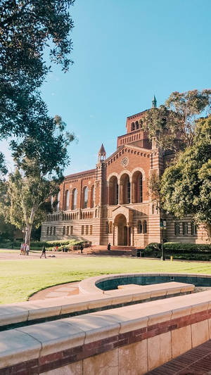 宏偉的紅磚大學建築，被綠樹和水景環繞。