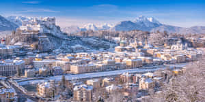 藍天下以山脈為背景的白雪覆蓋城市