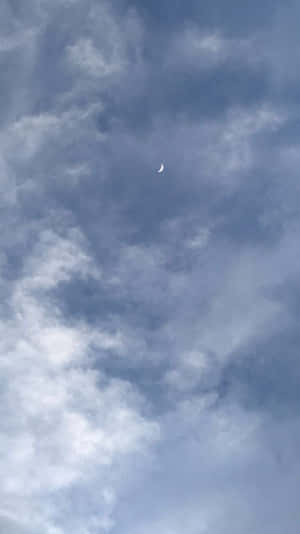 透過天空中柔和的藍白雲朵可見的月牙。 — 唯美雲朵動態 壁紙