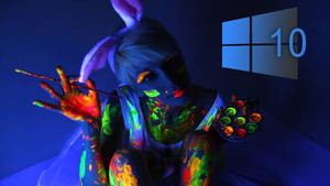被發光顏料覆蓋的人，在黑光下拿著畫筆和調色板，帶有Windows 10標誌。 — 天際線 壁紙
