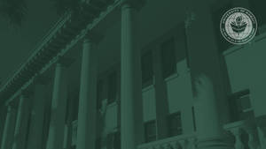 帶有藍綠色濾鏡的大學建築視圖，突出柱子和官方印章。
