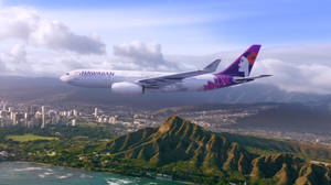 夏威夷航空飛機飛越沿海城市，有山脈和海洋。