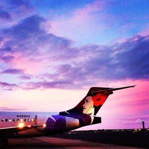 夏威夷航空飛機在日落時分停在跑道上，天空呈現粉紫色