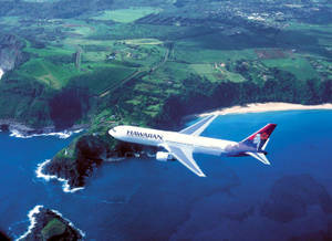 夏威夷航空飛機飛越熱帶島嶼，島上有綠色山丘和藍色海洋。