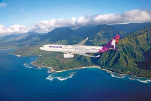 夏威夷航空飛機飛越熱帶島嶼，有山脈和海洋