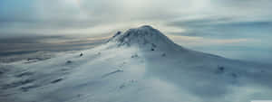 白雪覆蓋的山峰在雲層之上，天空灰暗