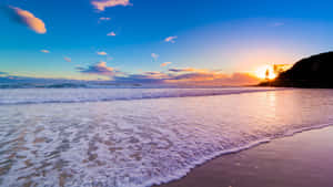 夕陽下海洋與海浪湧上沙灘，天空色彩繽紛 — 夏日氣息 壁紙