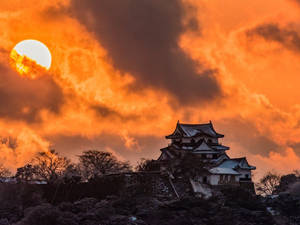 日落時分的歷史日本城堡，橙色天空，地上有雪
