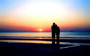 情侶在海灘上擁抱，夕陽西下，海洋倒影