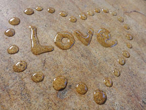 水滴串成 love 並喺石頭表面形成一個心形。