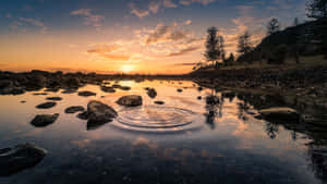水面上的夕陽，漣漪和岩石海岸