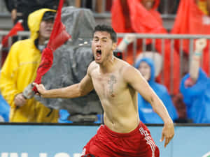 赤裸上身的足球員在雨中與身後球迷慶祝勝利。 — 足球 壁紙