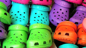 螢光色的Crocs木屐在零售環境中展示。 — 卡通鞋 壁紙