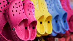 一排色彩繽紛的Crocs鞋在商店中展示。 — 卡通鞋 壁紙