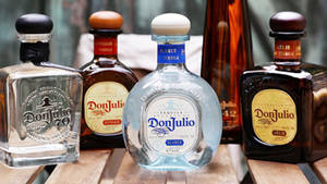 五個Don Julio龍舌蘭酒瓶展示在木質表面上。