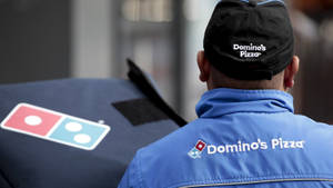 Domino's Pizza 送貨司機手持一個披薩盒。 — 薄餅 壁紙