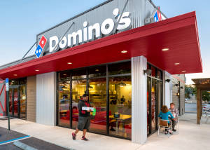 黃昏時分的Domino's薄餅餐廳，有送貨員和戶外座位。