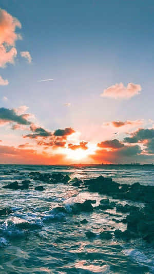 海上夕陽，海浪拍打岩石，色彩繽紛的雲彩 — 海灘日落 壁紙
