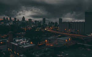 黑暗的風暴雲籠罩著城市景觀，閃爍的路燈和黃昏時分的車燈流線。