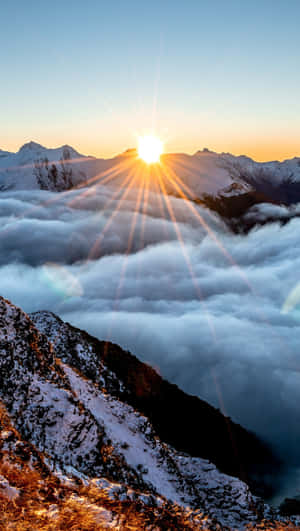 日出時，白雪覆蓋的山峰聳立於雲海之上 — 太陽 壁紙