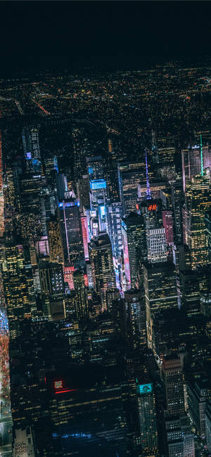 夜晚密集的城市天際線鳥瞰圖，建築物和霓虹燈閃閃發光。