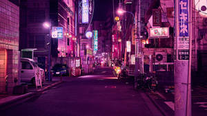 夜晚霓虹燈照亮東京小巷，有發光招牌和停泊車輛。