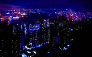 夜間城市天際線，燈火通明的摩天大樓和水面倒影。