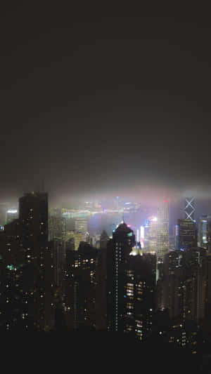 被薄霧籠罩的夜間城市景觀，摩天大樓燈火通明。 — 夜景城市 壁紙