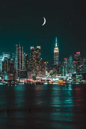 夜間城市天際線，有月亮和水面倒影 — 小米Pad 8 Pro 壁紙