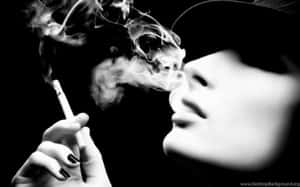 人物在黑白中手持香煙呼出煙霧。