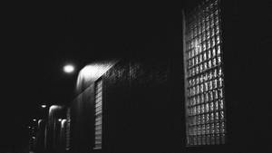 現代建築，帶有玻璃磚窗戶，夜晚被街燈照亮。