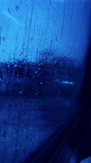 夜間車窗上的雨滴，背景是模糊的城市燈光。