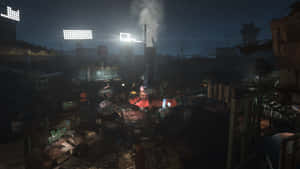 夜晚的工業廢墟，發光的泛光燈和從廢墟建築物升起的煙霧。 — 16:9 壁紙